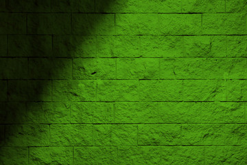 Green wall with a shadow. Green background with shadow. Green block wall.