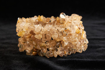 bracelet made of hairy semiprecious stone on black velor. close up