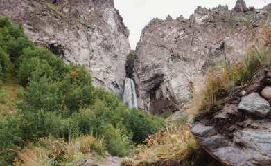 High rapid waterfall in the mountains, mountain river, nature. Caucasian waterfalls, Europe, big cold water.