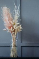 glass transparent vase with dry spikelets. A bouquet of dried flowers.