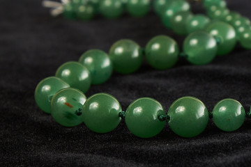 jade beads semiprecious stone on black velor. close up
