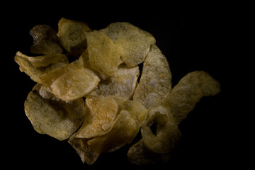 salted potato chips isolated black background