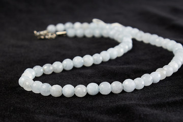 beads from aquamarine semiprecious stone on black velor. close up