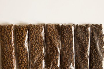 Seven different types of pet food are laid out one after another.