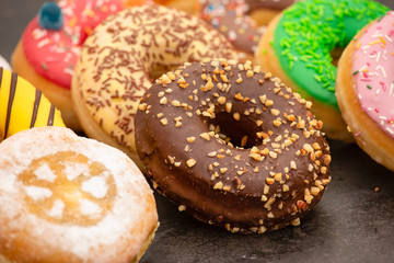 Dessert, Donuts, chocolate and strawberry circles, sugar and cream on Donuts and hot coffee cups, preparation for a break or party on the wooden table background.