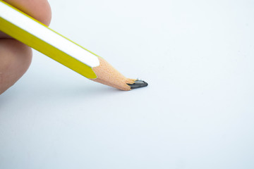 Person breaking the tip of a yellow and silver striped wood pencil crayon - Powered by Adobe