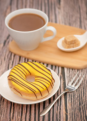 Dessert, Donuts, chocolate and strawberry circles, sugar and cream on Donuts and hot coffee cups, preparation for a break or party on the wooden table background.