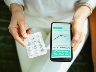 woman buying pharma using phone at home in sunny day