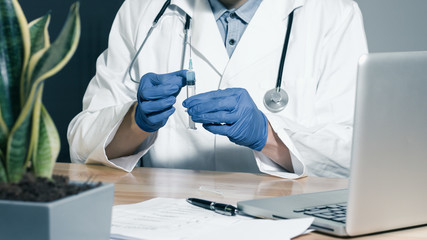 Doctor with syringe is preparing for vaccine injection