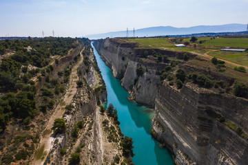 Obraz premium The Corinth Canal is a canal that connects the Gulf of Corinth with the Saronic Gulf in the Aegean Sea. It cuts Isthmus of Corinth and separates Peloponnese from the Greek mainland.