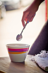 Fototapeta na wymiar colorful cup and spoon held by girl hand