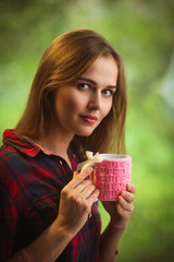 Beauty woman portrait holding hot drink on green background, selective soft focus on eyes.