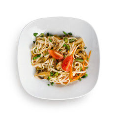 Fried udon noodles in a wok with bell pepper, Chinese cabbage and mushrooms. Traditional asian food. Isolated on a white background.