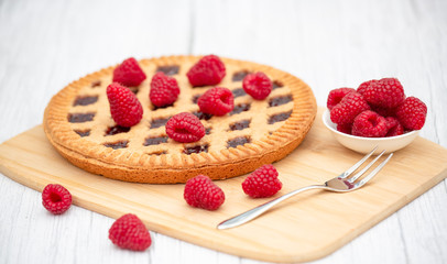 Dessert Raspberry Pie cake with strawberry or Fruit in a round bread for Break time or a party shot at the top view and copy space on a white wooden table.