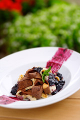 sliced pancake with wilde forest berry jam and ice cream dessert on  white plate with graden bavkground