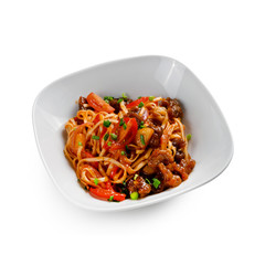 Fried udon noodles in a wok with pork in sweet and sour sauce. Traditional asian food. Isolated on a white background.