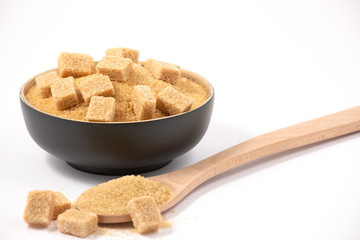Brown sugar in a wooden bowl or wooden spoon Sugar for health Use for cooking or desserts on white and sugar backgrounds.