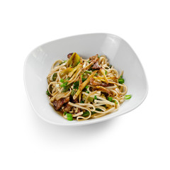 Fried udon noodles in a wok with slices of pork, green beans and bell pepper. Traditional asian food. Isolated on a white background.