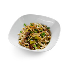 Fried udon noodles in a wok with slices of pork, green beans and bell pepper. Traditional asian food. Isolated on a white background.