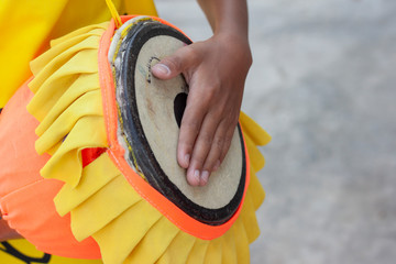 Hand of children play hit long drum thai with joyfully.
