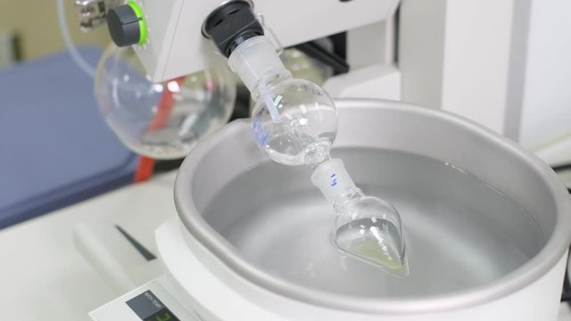 Remove solvent out from the sample by using a rotary evaporation machine. The glass bottle was rotated in the water bath which need to control temperature. Education and industrial concept.
