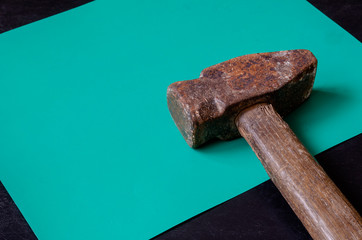Old sledgehammer on a turquoise background.