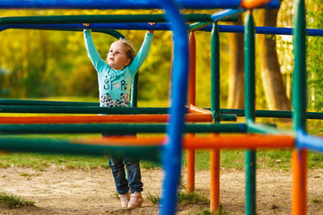 Obraz premium Little beautiful girl on a walk between the colored maze