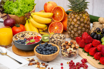 Group Fruits Breakfast mixed vegetables with salad bowl, nuts bowl, strawberry, banana, and pineapple, orange juice,  vitamin c in food  nature for health and diet in the top view on the wood table.