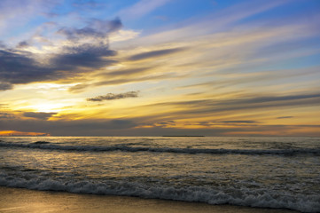 Sunset over the sea. Reflection of sunlight in the sea waves. The sky in the sunset rays.