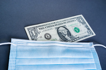 Hygienemaske mit einer 1 Dollarnote zum Thema Wirtschaftskrise nach der Corona Pandemie