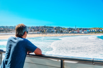 Traveller businessman wearing sunglass enjoys landscape view of Bondi beach, the most famous tourist attraction at Sydney city, Australia.