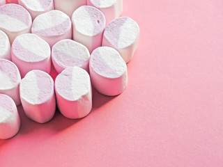 Pink and soft marshmallows on pink background with copy space.                                                            