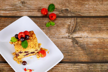 Portion of blueberry coffee cake on wooden background.