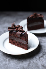 2 slices of sweet Chocolate cakes on the grey table, dark background.