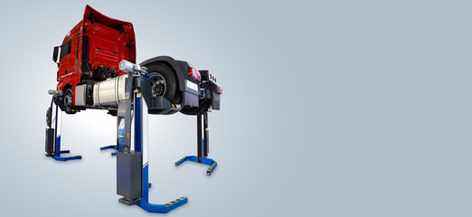 Truck on a lift in a car service. Gray background, copy space