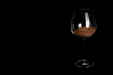 wine glass filled with buckwheat on a black background