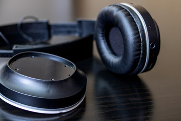 Broken black headphones on a wooden table