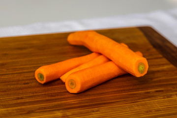 freshly picked, washed carrots,  on a wood cutting board