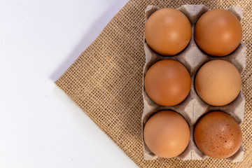  Raw Chicken eggs in cardboard egg box on brow mat. Eggs in the package.