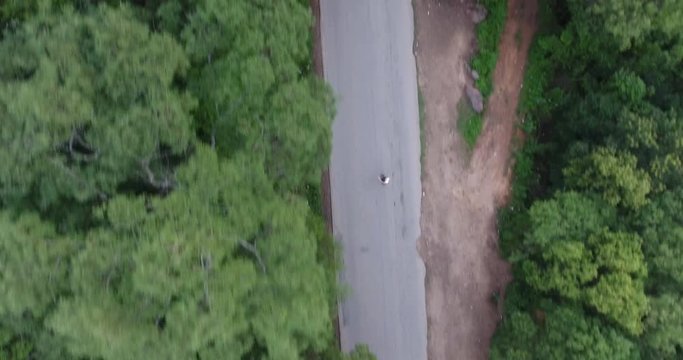 Young Caucasian Man in White Shirt Skates on an Asphalt Road in the Middle of Nature in Samaipata, Santa Cruz / Bolivia