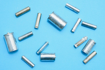 Close up of spent used rechargeable Nickel Metal Hydride (Ni-MH) battery on grey background, flat lay. Old Nickel-Cadmium (Ni-Cd) batteries without a protective shell with corrosion and rust