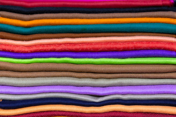 A stack of multicolored wool scarves in close-up.