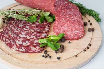 Thinly sliced Smoked sausage on a wooden Board.