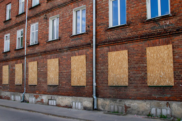 Fototapeta na wymiar Brick house. The windows on the lower floor are clogged with boards.