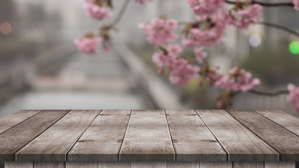 Wood table top on blurred background of pink cherry blossom flowers. display or montage your products. 