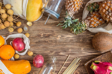 Set of exotic tropical fruits on wooden rustic background - papaya, mango, pineapple, dragon fruit, orange, coconut, passion fruit, longan. Top view. Zero waste concept