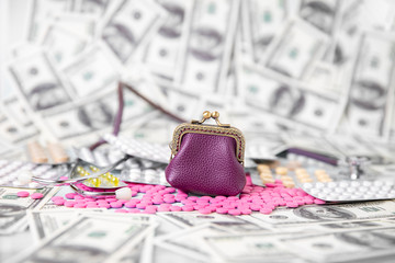 A scattering of pink medical pills and white cans against a background of dollar bills.