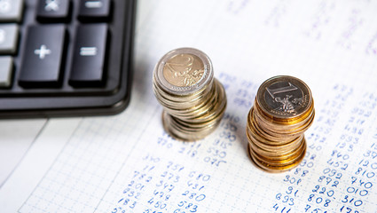 Close up of a calculator and coins on a business background