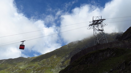 Cable Cart Sliding Down a Lush Green Mountain

