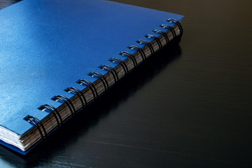 Blue notebook on a black wooden table